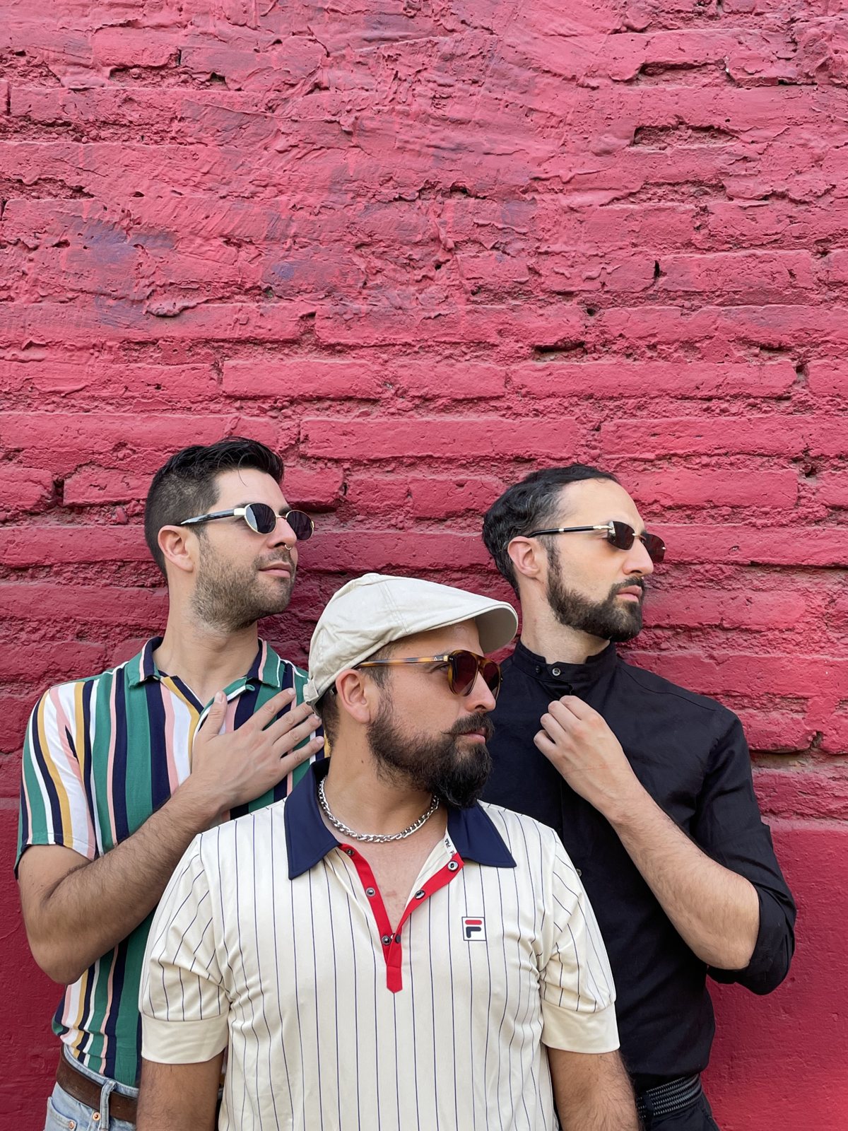 Los Semejantes posando frente a un muro rosado